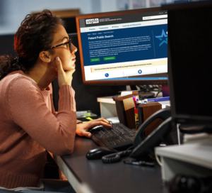 woman sitting at desk looking at computer screen